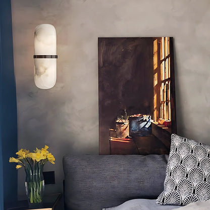 Decorative wall art above a bed in a bedroom setting with a lamp and flowers.