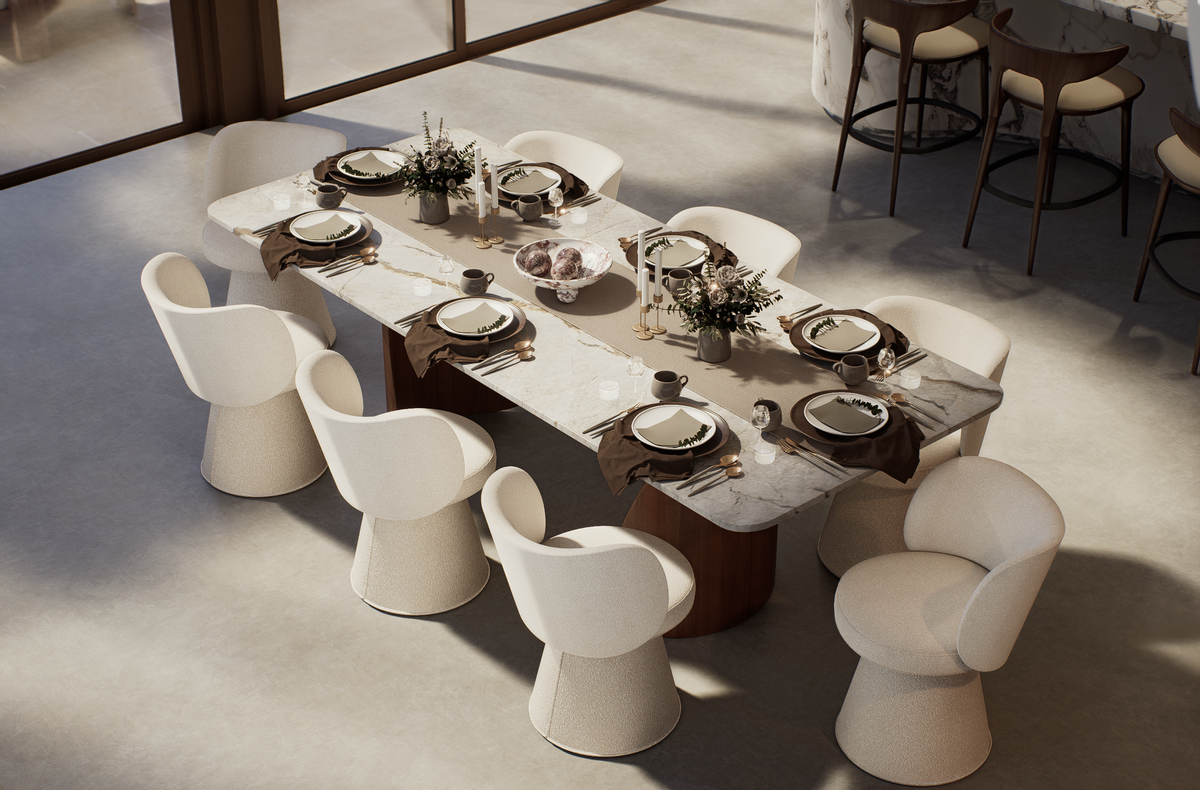 A modern dining room scene showing a rectangular marble-top dining table surrounded by white upholstered chairs. The table is set with plates, cutlery, folded brown napkins, and small floral centerpieces.