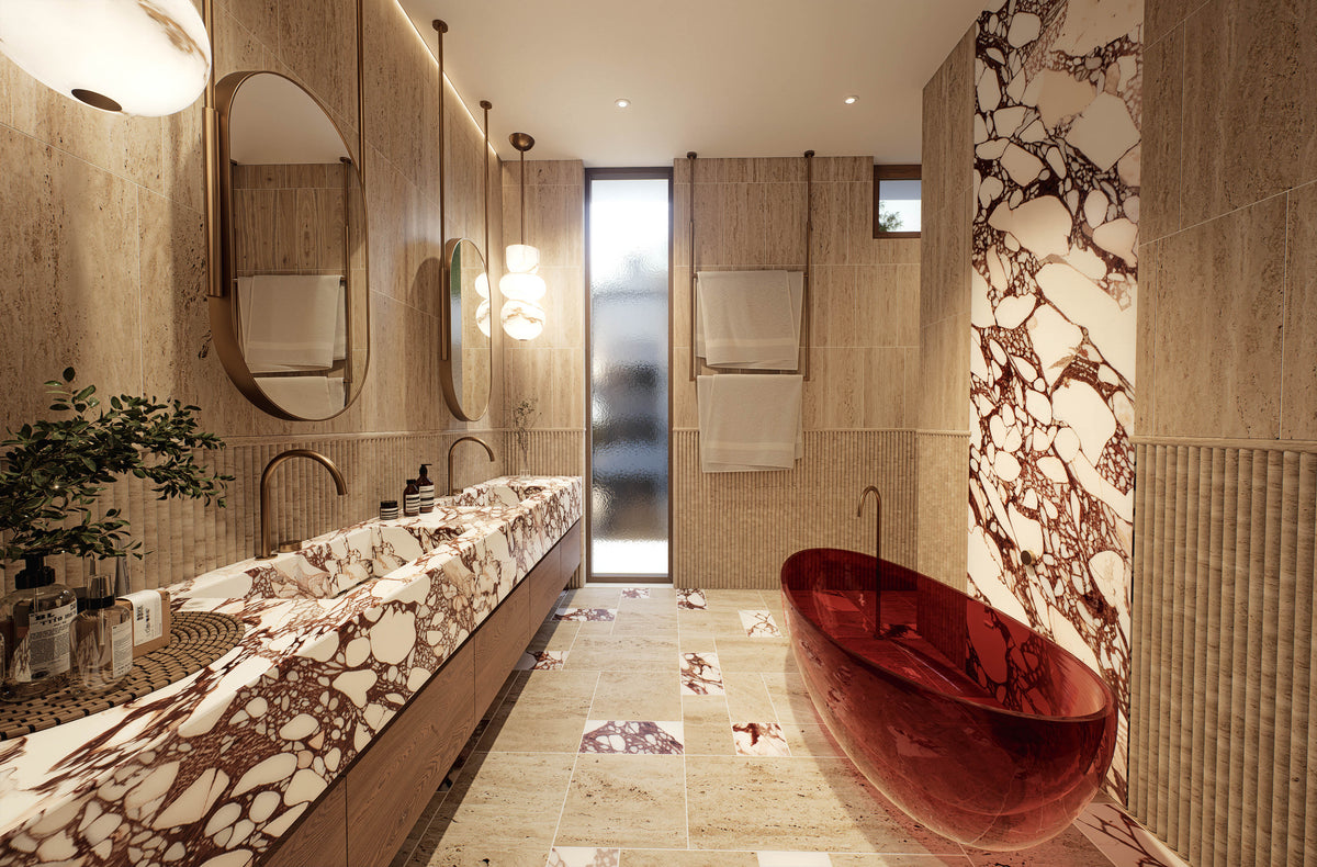 A luxury modern bathroom featuring a striking glossy red freestanding bathtub set against a wall with dramatic brown and white marble veining. The bathroom has a long double vanity with matching marble-look countertops, round wall mirrors, and warm wood paneling.